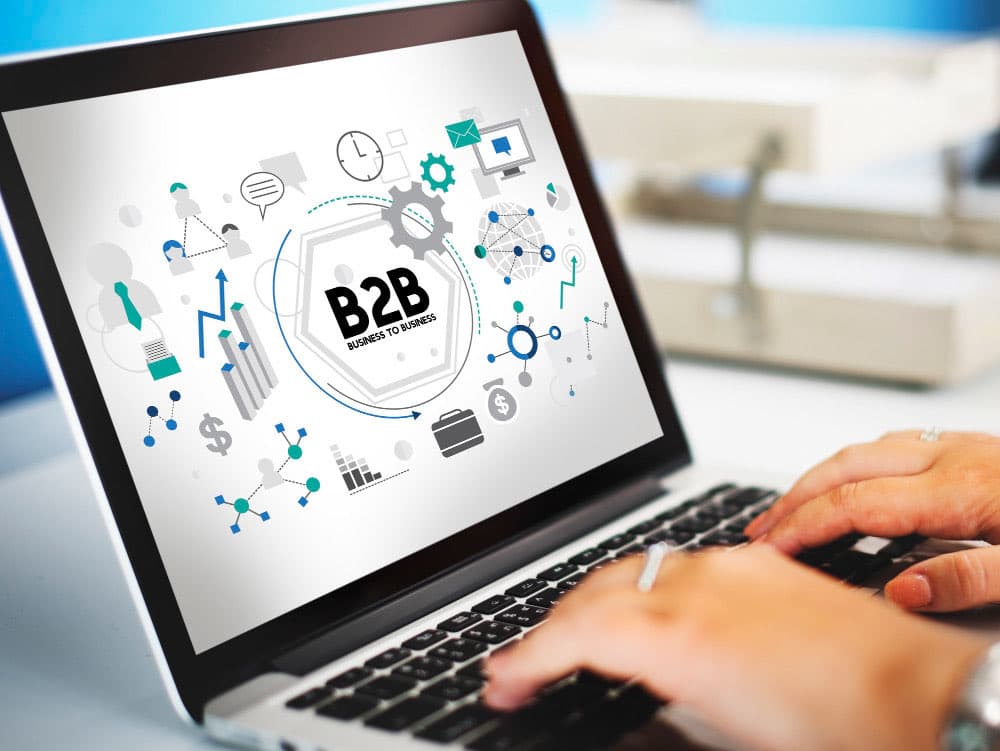 Commerciale B2B al lavoro su laptop con dashboard CRM: pipeline trattative, schede cliente e dati del reparto vendite su sfondo aziendale