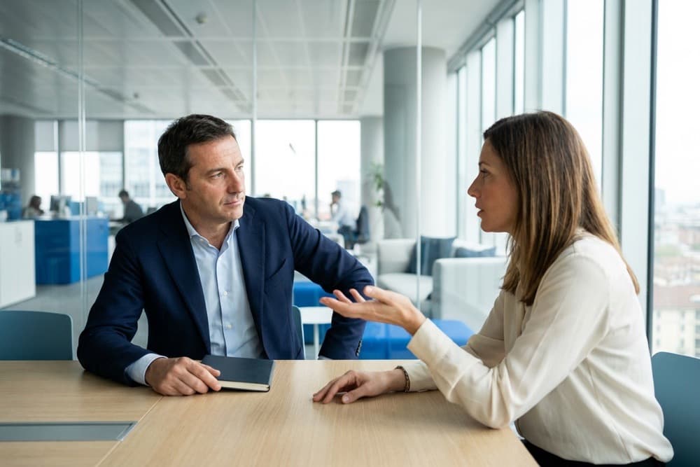 Commerciale B2B che ascolta con attenzione un cliente durante un incontro: lo scavo nella vendita con domande potenti per far emergere il vero bisogno