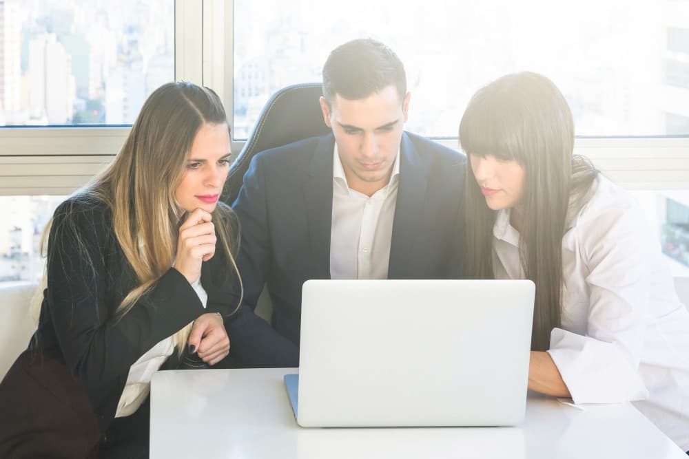 Team di una PMI valuta diversi software gestionali aziendali su laptop e documenti in una sala riunioni, confrontando criteri di scelta e funzionalità per il 2026