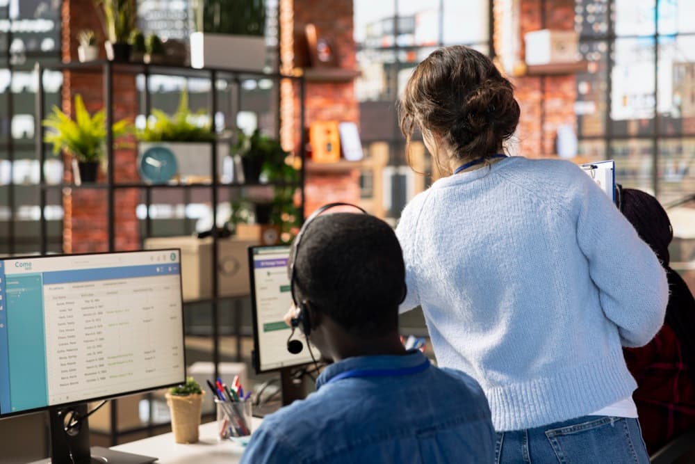 Imprenditrice davanti a un monitor con un software gestionale aziendale aperto su moduli contabilità e magazzino, mentre prende appunti su un quaderno — glossario dei termini per chi parte da zero